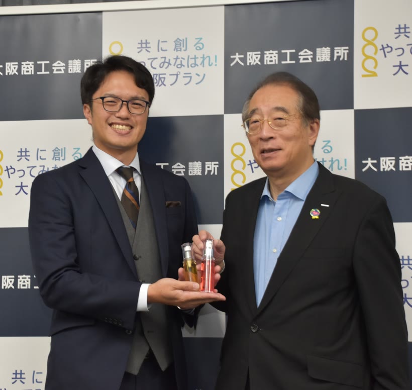 大阪商工会議所での記者会見で製品サンプルを手にする様子